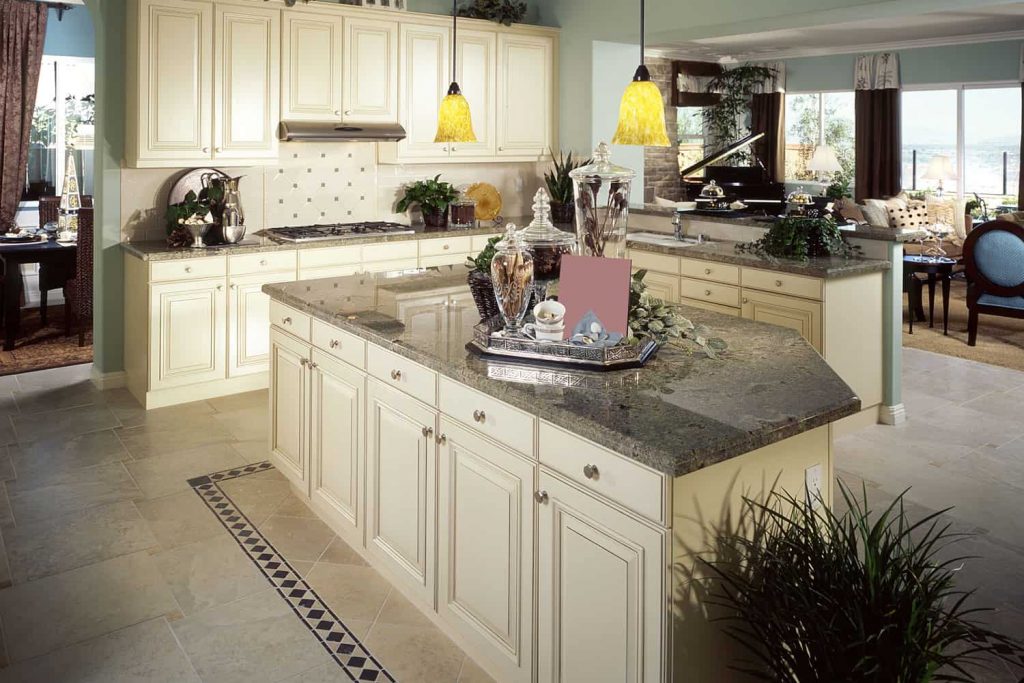 Elegant classic inspired kitchen with cream painted cupboards and cabinets with a brown granite countertop